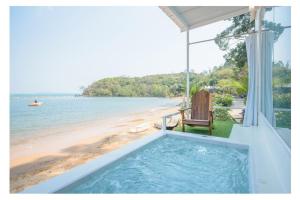 柴老海滩贝壳村度假酒店的海滩旁的热水浴池,带长凳