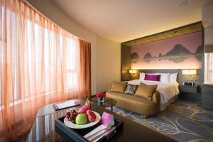 香港香港九龍東皇冠假日酒店的酒店客房,配有一张床和一张桌子,还有一碗水果