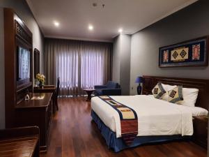 萨帕Pistachio Hotel Sapa的配有一张床和一张书桌的酒店客房