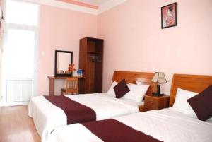 大叻New Sleep in Dalat Hostel的一间卧室设有两张床和窗户。
