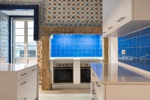 里斯本Succeed Terreiro do Paço Suites的厨房的墙壁上铺有蓝色瓷砖。