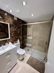 马拉加Apartamentos Prestige Malaga Suites III的带淋浴、卫生间和盥洗盆的浴室