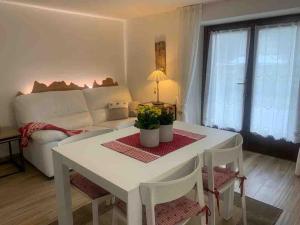 平佐洛Pinzolo, grazioso appartamento, wellness a 100 metri的客厅配有白色桌子和沙发