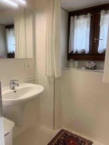 平佐洛Pinzolo, grazioso appartamento, wellness a 100 metri的一间带水槽、卫生间和镜子的浴室