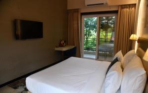瓦伊Gandharv Resorts的卧室配有一张大白色床和窗户