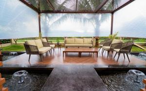 瓦伊Gandharv Resorts的客厅配有椅子和桌子,设有池塘