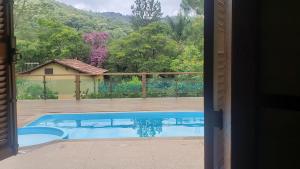 莫埃达Sítio Alazão的从房子的门口可欣赏到游泳池的景色