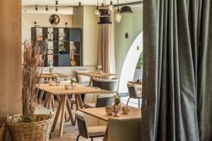 索普拉布扎诺Gloriette Guesthouse Hotel & Restaurant的一间带桌椅和窗帘的餐厅