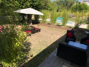 阿宰勒里多Domaine Plessis Gallu - vacation cottage rental的庭院配有桌椅和遮阳伞。