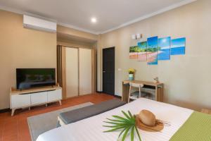 湄南海滩Sea&Sky Beach Resort的一间卧室配有一张床和一台平面电视