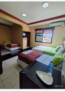 巴克里索莫雷诺港洛斯阿尔加鲁博斯旅舍的一间卧室配有两张床和一张带一瓶水的书桌。