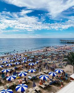 皮特拉利古Hotel Maremola的蓝白遮阳伞海滩和海洋
