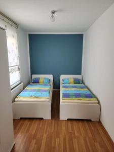 多特蒙德Wohnung in Dortmund的配有蓝色墙壁和木地板的客房中的两张床