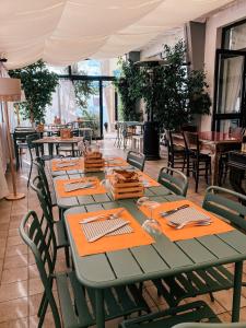 皮特拉利古Hotel Maremola的餐厅配有桌椅,提供绿桌