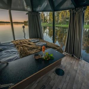 基律纳Aurora River Camp Glass igloos & cabins的船上的一张床,享有水景