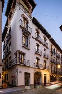 格拉纳达Santa Escolástica en pleno centro de Granada的白色的建筑,在街上设有阳台