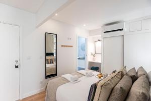 波尔图Urban House by LovelyStay的白色卧室配有床和镜子