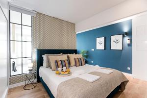 波尔图Urban House by LovelyStay的一间卧室设有一张蓝色墙壁的大床