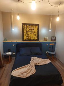莫尔比耶Style of Industry的一间卧室配有一张蓝色的床,床上有毯子
