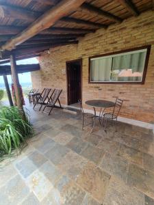 卡兰卡斯Pousada Mirante Serra Verde的一个带桌椅和砖墙的庭院