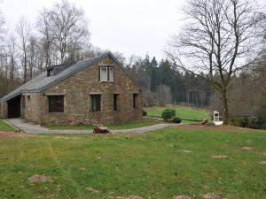 斯图蒙Attractive holiday home in Stoumont with garden的一座石头房子,位于一个有院子的田野里