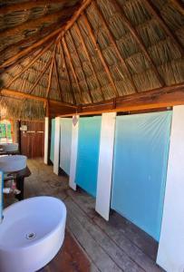 奥尔沃克斯岛Balam Camping & cabañas的浴室配有白色浴缸和木制天花板