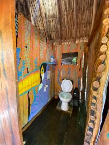 奥尔沃克斯岛Balam Camping & cabañas的浴室设有卫生间,墙上挂有绘画作品