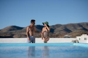 伊奥斯乔拉Kritikakis Village Hotel的站在游泳池旁的男人和女人
