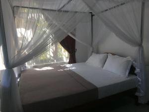 本托塔Sisila Villa的一间卧室配有床和带窗帘的窗户