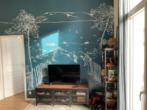阿卡雄T2 stylé/calme et confortable的客厅配有电视和蓝色的墙壁