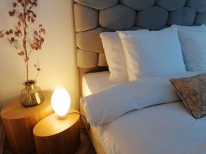 那慕尔Appartement Fernand Namur的一间卧室配有一张床和一张桌子上的台灯