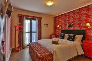坎波斯杜若尔当乔丹宾馆的一间卧室配有大床和红色壁纸