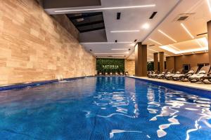 GnjilaneAstoria Luxury & SPA的酒店的大型游泳池配有椅子