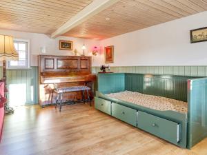 莱斯Holiday home Læsø LIII的一间卧室配有一张床和一架钢琴