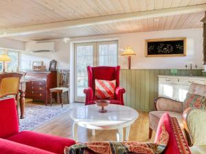 莱斯Holiday home Læsø LIII的客厅配有红色椅子和桌子