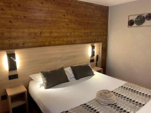 埃姆布能Logis Hotel-Restaurant Spa Le Lac的卧室配有白色的床和木墙