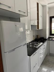 拉马萨Marsa Authentic Luxury Appart 1的厨房配有白色橱柜和白色冰箱。