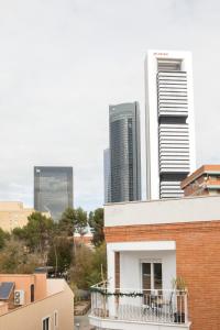 马德里Apartamentos Las Torres的高层建筑前设有阳台的建筑
