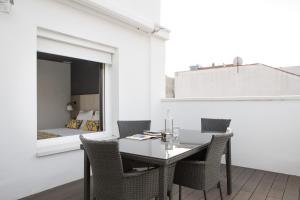 马德里Apartamentos Las Torres的一间带桌椅和一张床的用餐室