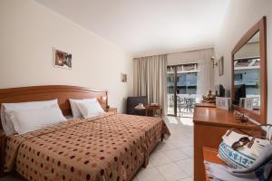尼基季博尔费海滩度假酒店的酒店客房带一张床铺、一张书桌和一间卧室