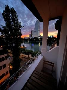 巴塞尔Charmante Altbauwohnung am Rhein的日落时分从大楼的阳台上欣赏美景