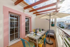 布德恩斯Casa Ensolarada的阳台配有桌椅和遮阳伞。