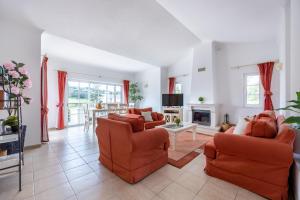 布德恩斯Casa Ensolarada的客厅配有橙色椅子和壁炉