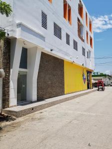 CiénagaHotel Don Jose的街道边的白色和黄色建筑