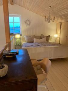 洛默Landhaus „Blattgold“的一间卧室配有一张带桌子和椅子的床