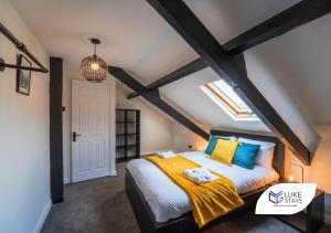 盖茨黑德Luke Stays - Brighton Road的一间卧室配有一张大床,提供黄色和蓝色的枕头