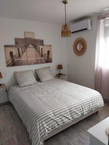 阿尔勒logement atypique的卧室配有一张床,墙上挂有绘画作品