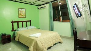 AguadulceHotel Interamericano的一间卧室配有一张床、一张桌子和一台电视