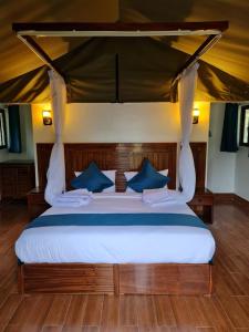纳库鲁Ol Muteita Lodge的一张带蓝色枕头的大床