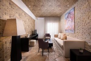 波托什Afrodite Suites的带沙发和砖墙的客厅